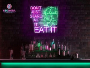 "Don't Just Stare at It Eat It" custom neon sign glowing in modern kitchen - Neonora funny food decor
