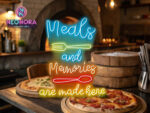 "Meals and Memories Are Made Here" warm-white LED neon sign glowing above a modern dining table with plates and wine glasses.