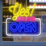 Bright and colorful "Yes We Are OPEN" LED neon sign with USB power and mounting chain for storefront, cafe, or small business window decor.